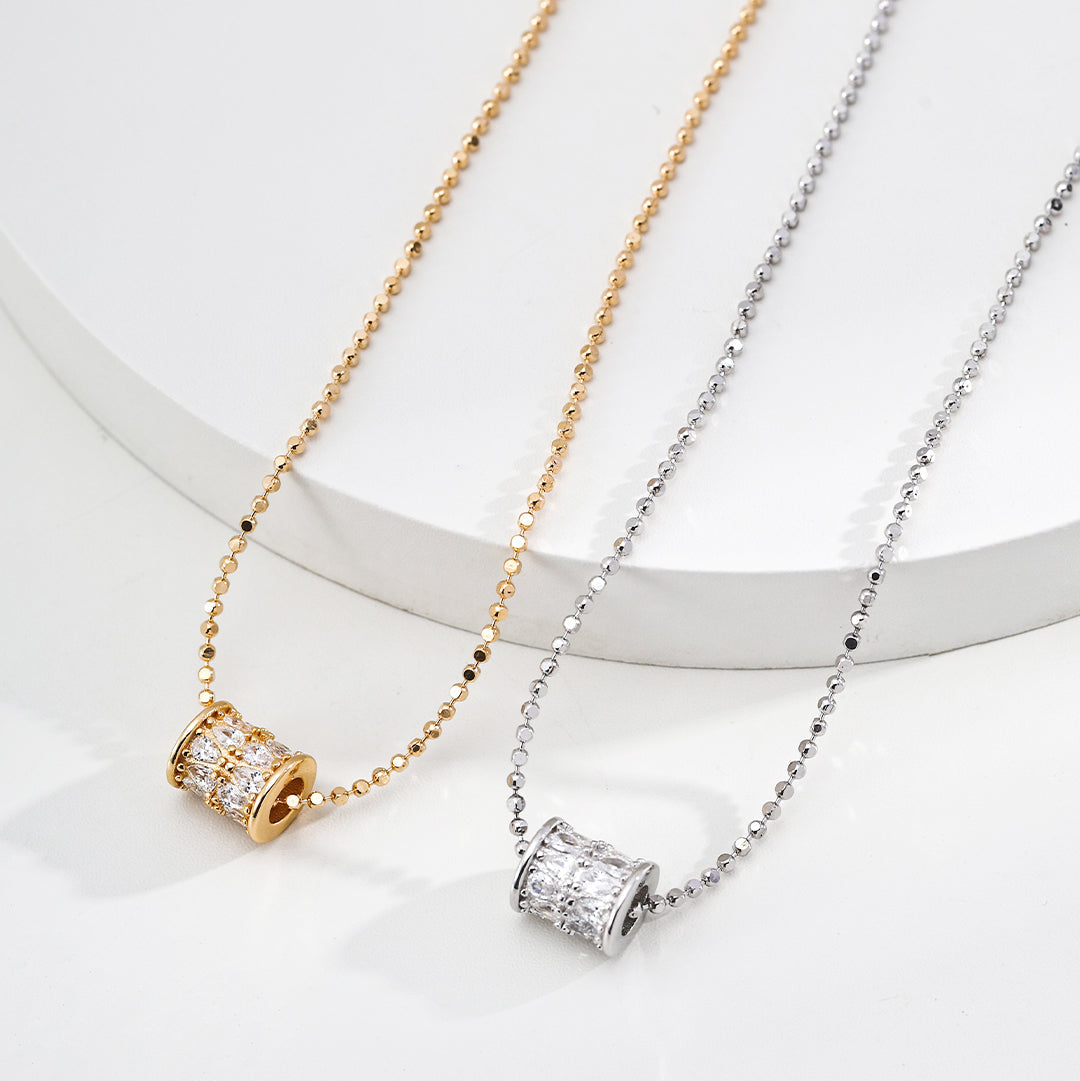 Two necklaces with pendant designs on a white background